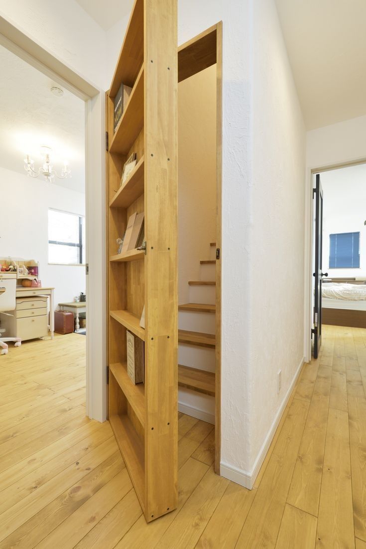 an open book shelf in the middle of a room with wooden floors and white walls