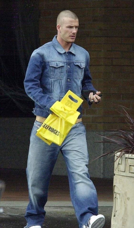 a man walking down the street carrying a yellow bag