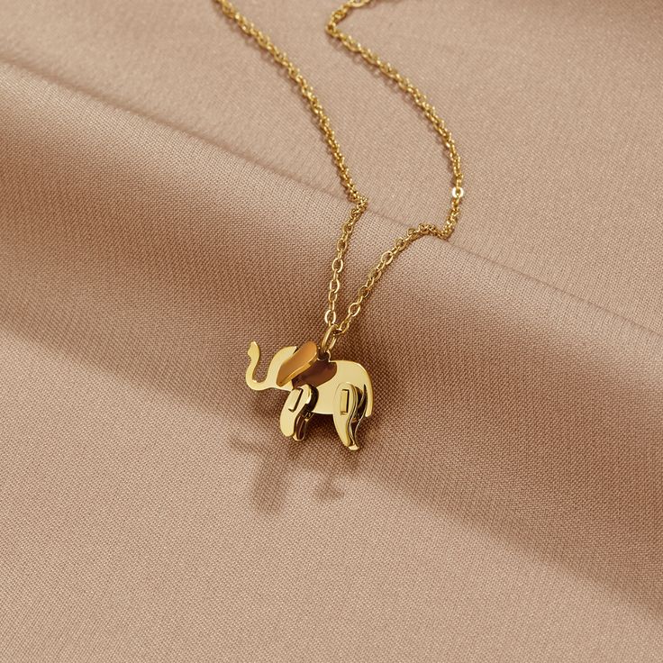 Elephants are one of the strongest and largest animals on our planet today. These beautiful creatures traditionally represent strength, power, and loyalty. Elephants are known for their clever natures and are often seen as good luck symbols throughout the world. Invite peace and clarity into your life when you wear this adorable necklace. Never forget the power you hold within yourself. Waterproof & tarnish-free Stainless steel, gold-plated Size: 15.7in (+ 2in adjustable) Size (pendant): 0.4in x 0.6in Lobster clasp closure Hypoallergenic, lead & nickel free If you aren't in LOVE with your purchase, please let us know within 30 days of receiving your item, and you'll receive a stress-free refund. Luck Symbols, Elephant Necklace Gold, Hand Jewelry Rings, Buy Gold And Silver, Gold Elephant Pendant, Good Luck Symbols, Candle Pedestal, Gold Mangalsutra Designs, Gold Necklace Indian Bridal Jewelry