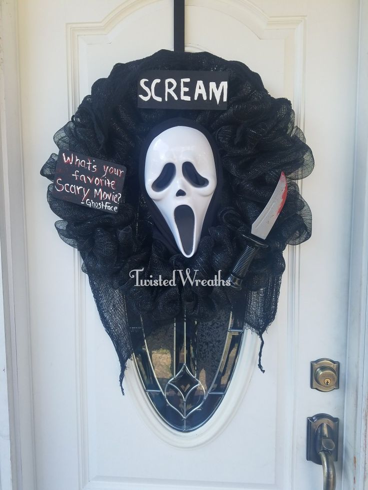 a halloween wreath with a white mask on it