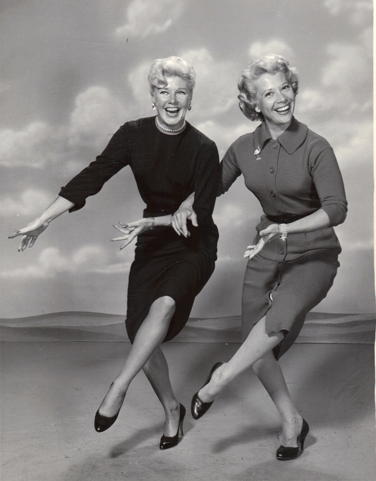 two women in black and white posing for the camera with their legs spread wide open