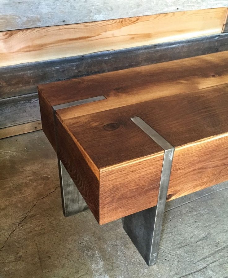 a wooden bench with metal legs on concrete floor