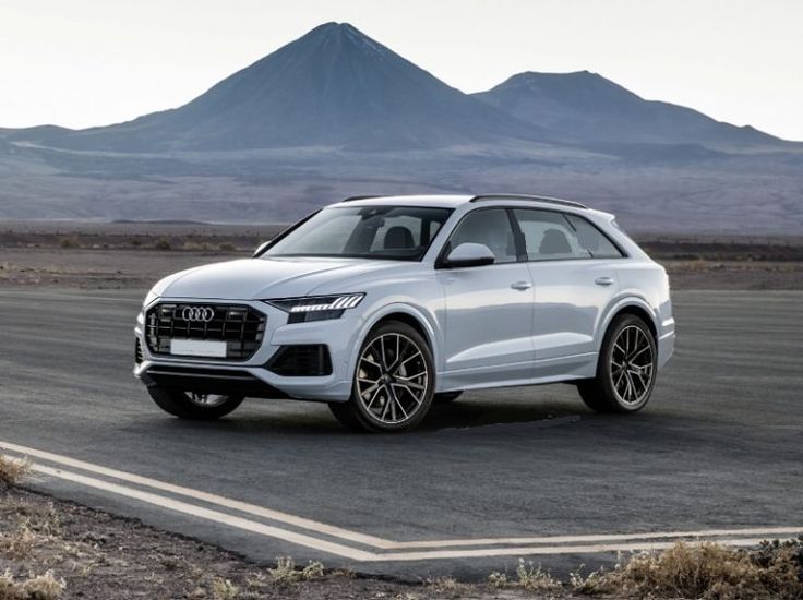 the new audi q3 suv is driving on an empty road with mountains in the background