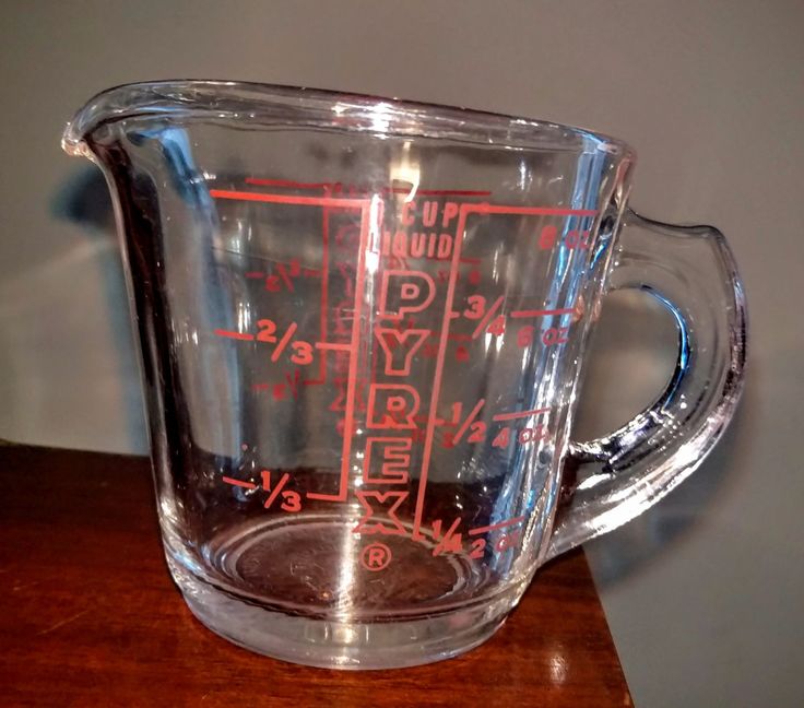 a glass measuring cup sitting on top of a wooden table