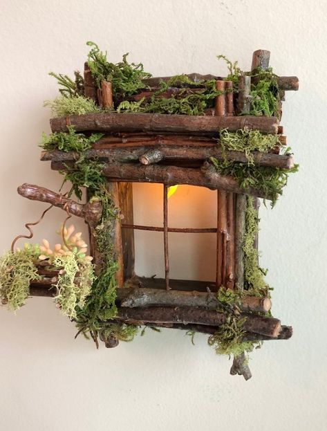 a small wooden birdhouse with moss growing on it's sides and a lit candle in the window