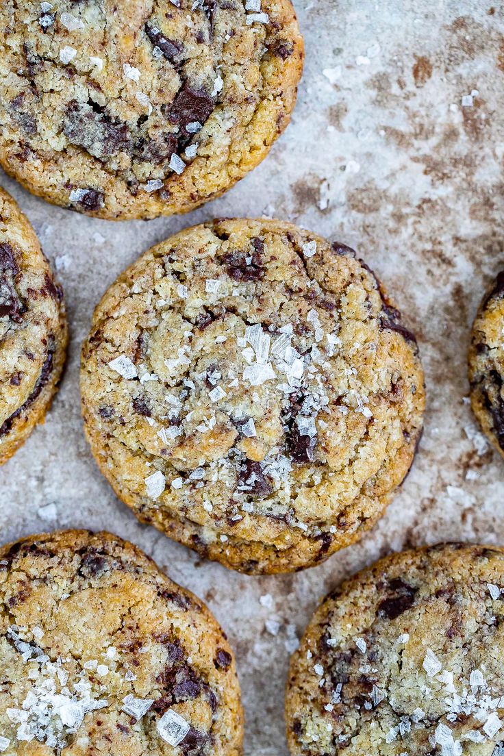 chocolate chip cookies with coconut flakes on a baking sheet lined with parchment paper and sprinkled with powdered sugar