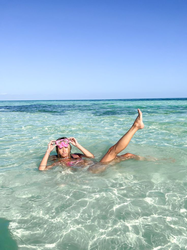 a woman laying on top of a body of water