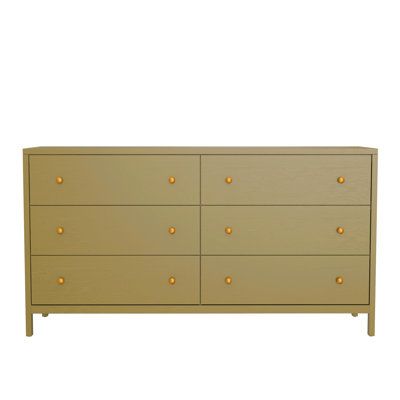 the chest of drawers has gold knobs on it