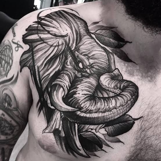 a man's chest with an elephant tattoo on it