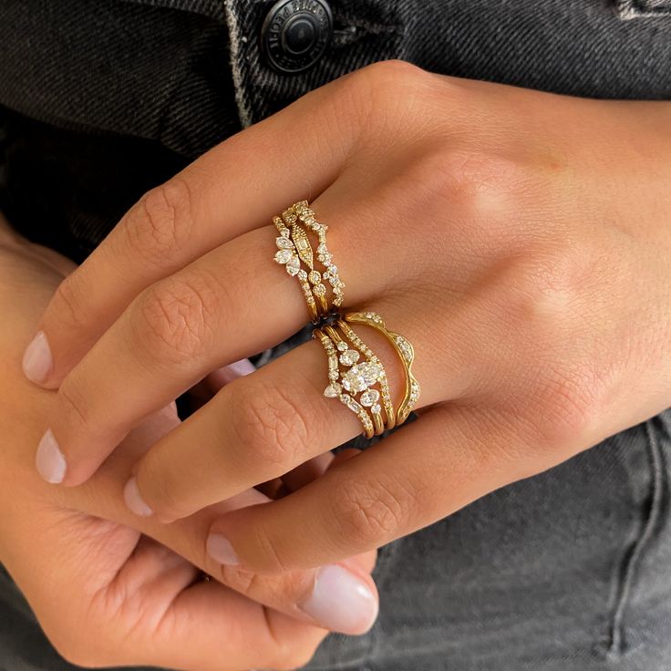 a woman's hand with three different rings on her finger and the other ring is gold