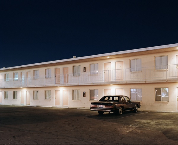 a car parked in front of a motel at night