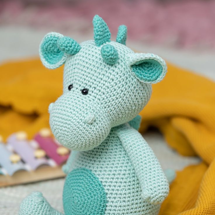 a crocheted stuffed animal sitting on top of a blanket