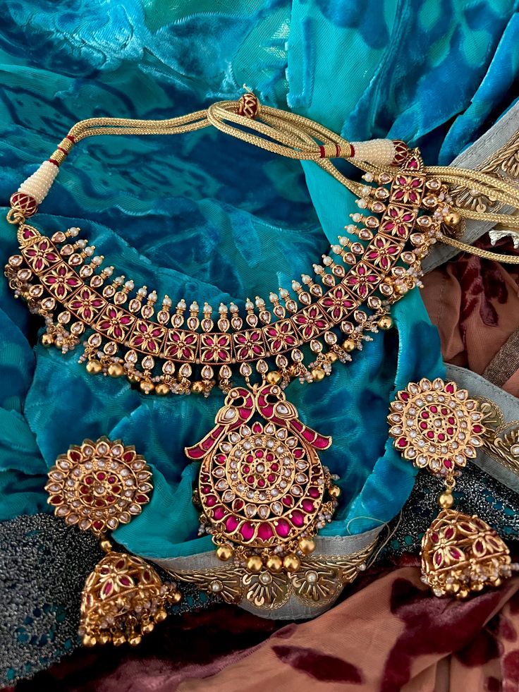 Experience opulence with our exquisite jewelry set, crafted by the same skilled artisans who create real gold pieces. Fashioned from top-quality materials, it mirrors the allure of genuine gold without the price tag. Perfect for destination weddings and parties, its elegance is matched only by its convenience and security for travel. Product Details: Material: Each piece is meticulously handcrafted from high-quality brass and Kundan Stones. Necklace Dimensions: Weight: 85 grams Closure Type: Pre Luxury Gold Festive Jewelry, Elegant Kundan Temple Necklace In Yellow Gold, Luxury Stone Work Jewelry Sets For Festive Occasion, Elegant Yellow Gold Kundan Temple Necklace, Elegant Heavy Gold Jewelry Set, Luxury Gold Jewelry For Festive Season, Festive Luxury Gold Temple Necklace, Festive Luxury Gold Jewelry, Traditional Jewelry Sets With Elegant Round Design