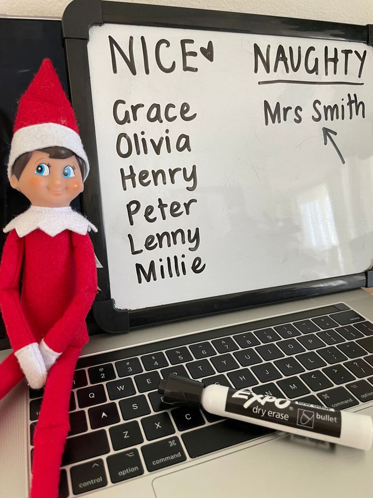 an elf is sitting in front of a laptop with marker on the keyboard, next to a pen