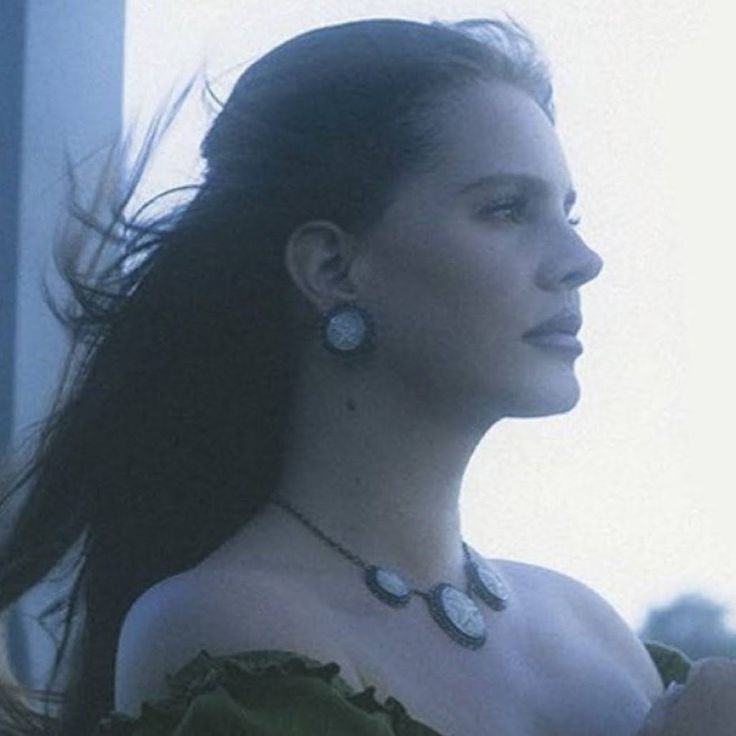 a woman in a green dress is looking off into the distance