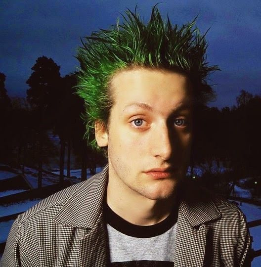 a man with green hair wearing a jacket