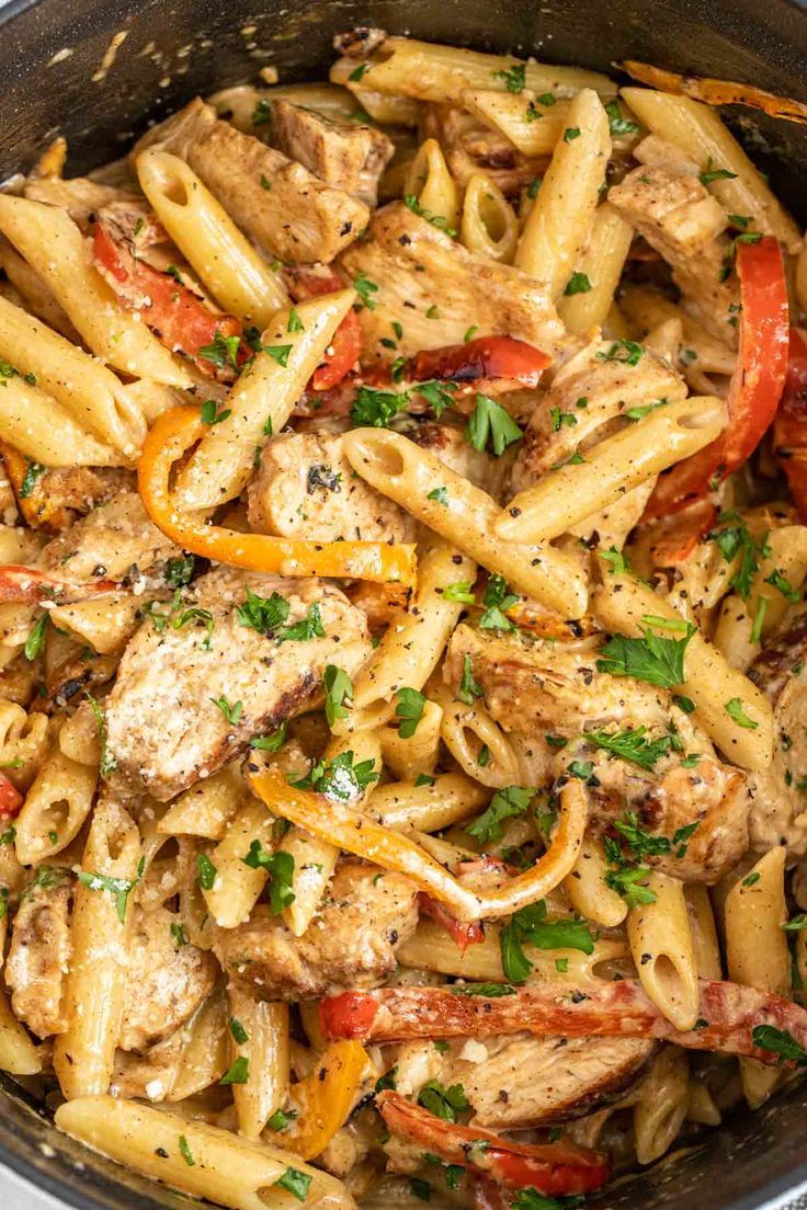 pasta with chicken, peppers and parsley in a skillet