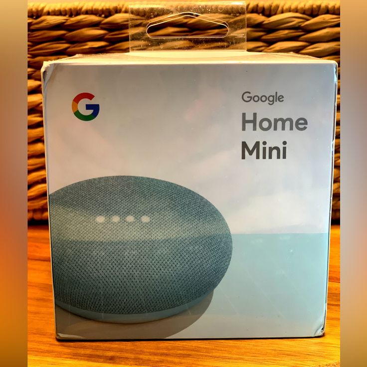 the box for google home mini is shown in front of a wicker basket with it's lid open