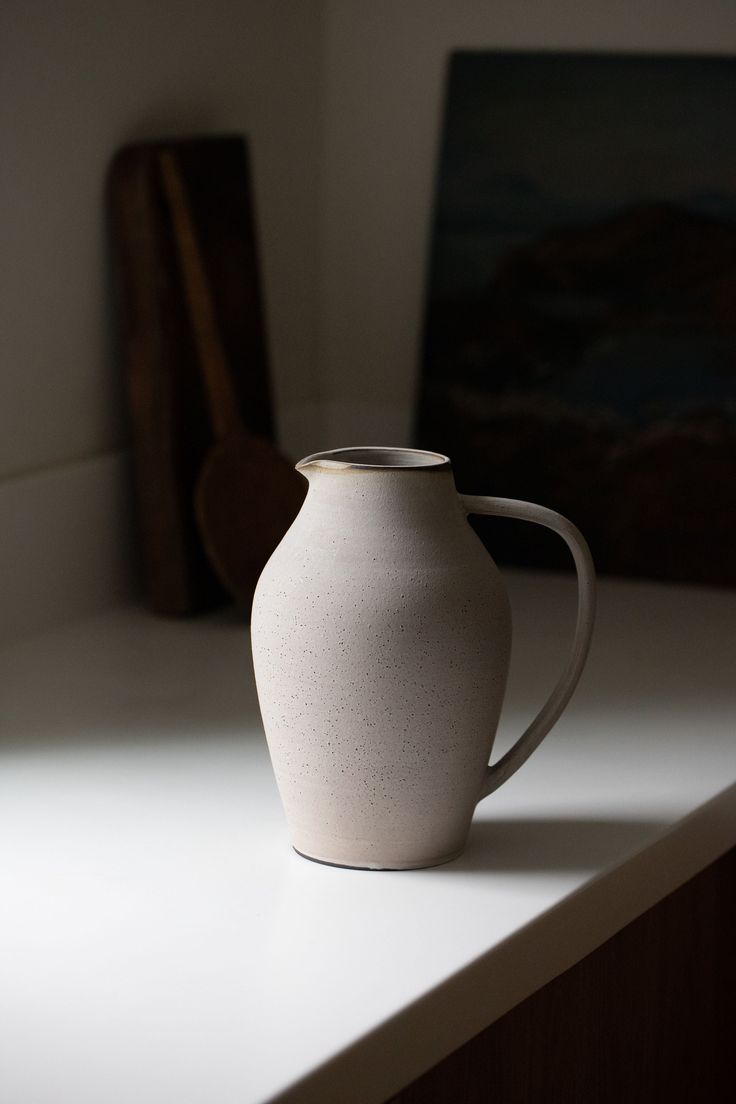 a white vase sitting on top of a counter