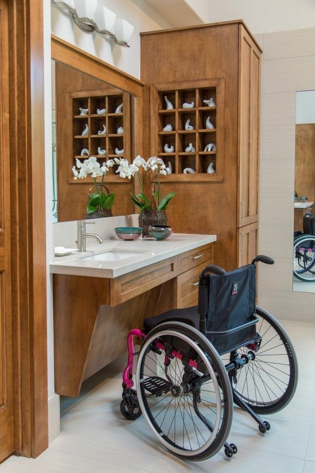 a wheelchair is parked in front of a bathroom sink and cabinet with flowers on it