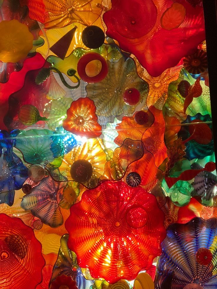 many colorful glass flowers are hanging from the ceiling