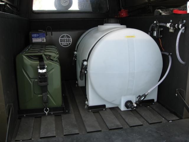 two tanks are in the back of a truck with its doors open and hoses attached to them