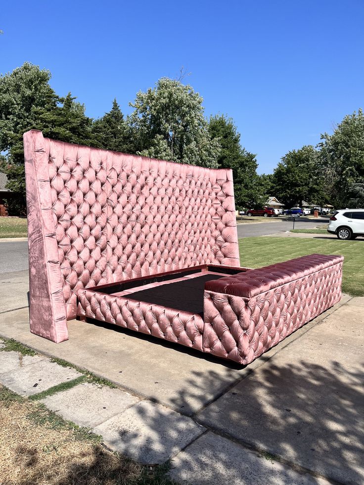 a large pink bed sitting on top of a sidewalk