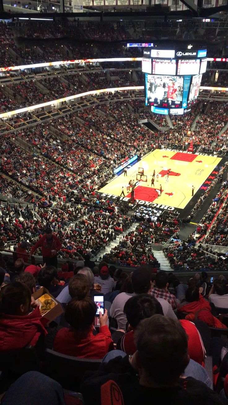 a basketball game is being played in an arena with many people sitting on the bleachers