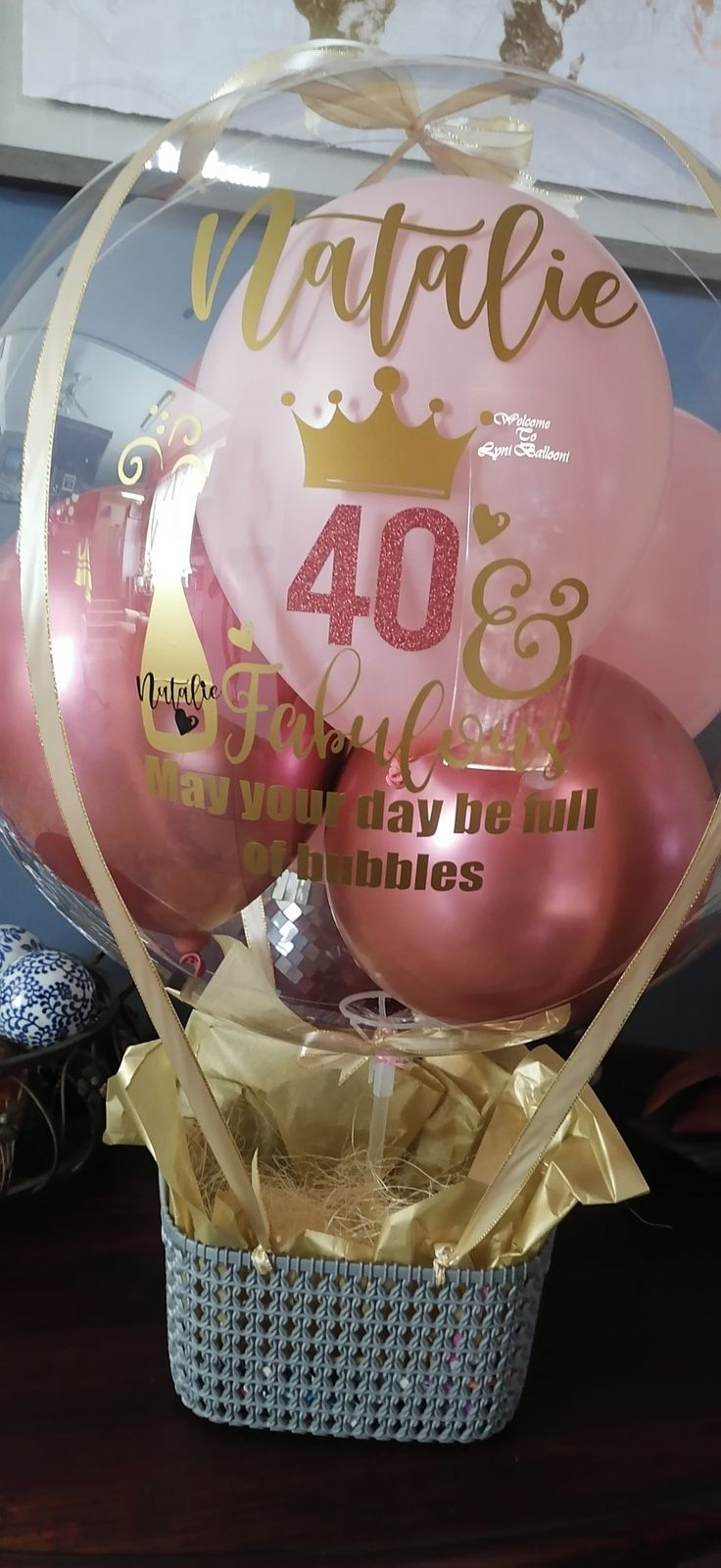 some pink and gold balloons in a basket