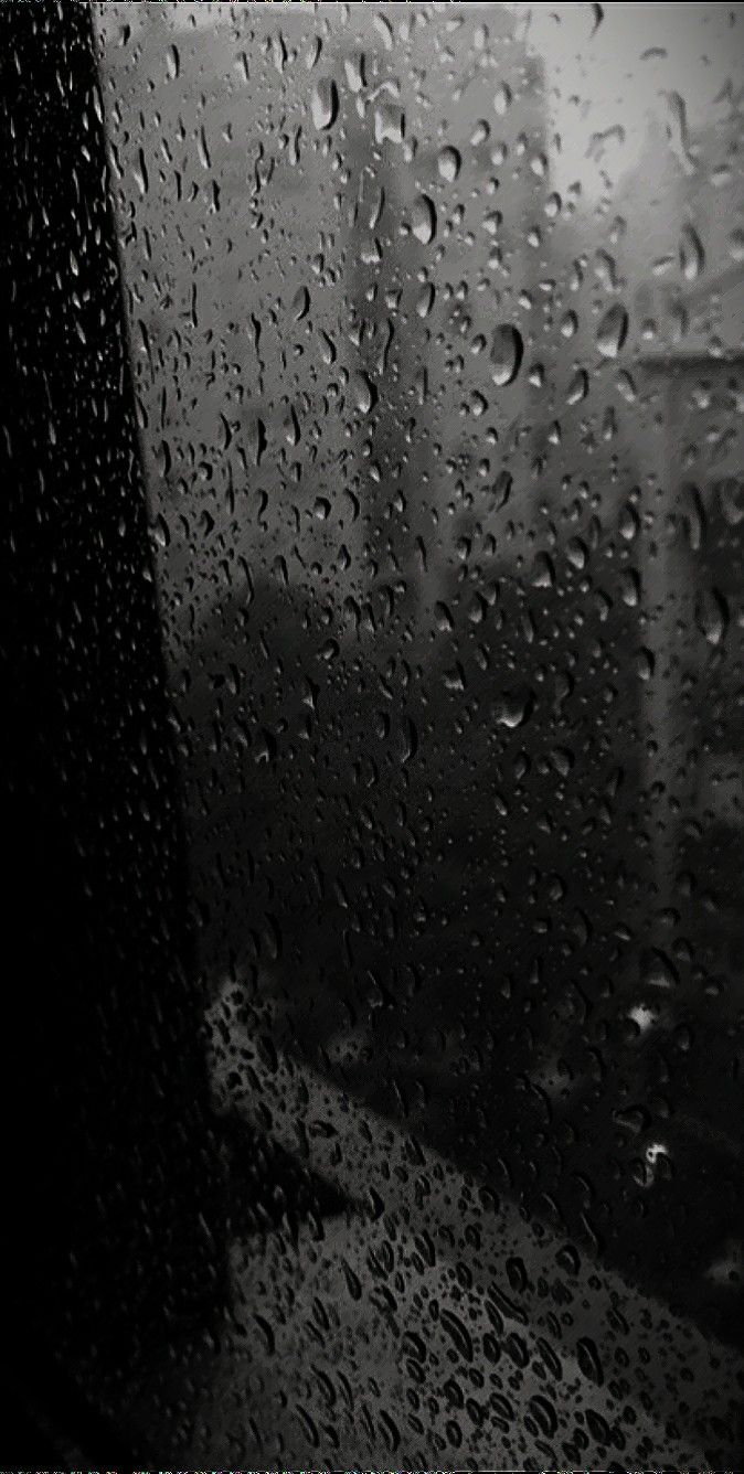 black and white photo of rain drops on window