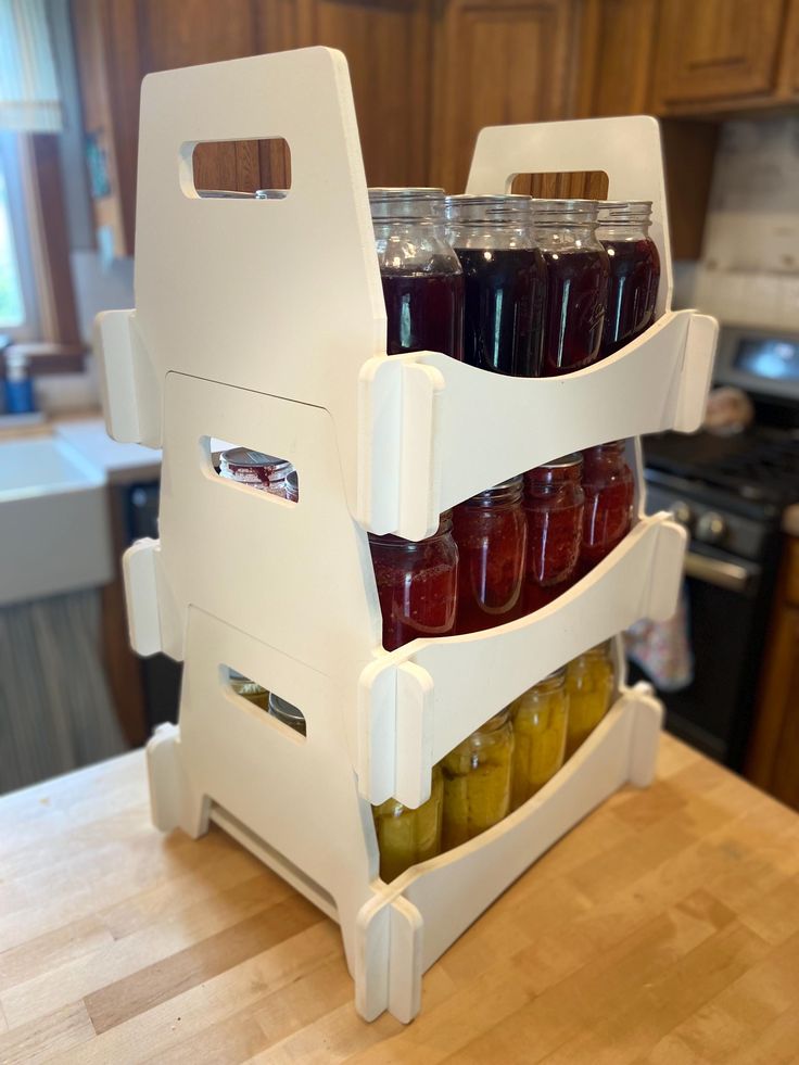 three jars of pickles are stacked on top of each other in front of an oven