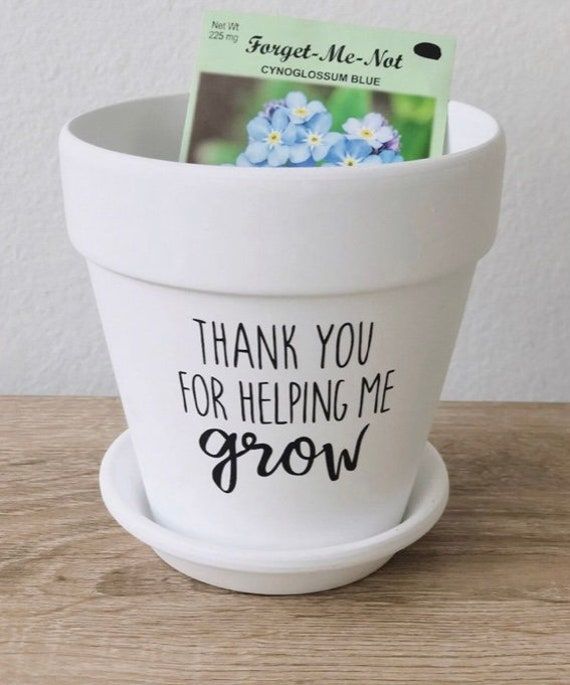 a white flower pot with a thank you for helping me grow card in it