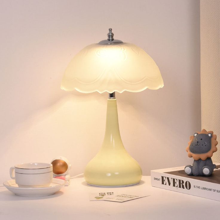 a table with a lamp on top of it next to a cup and saucer