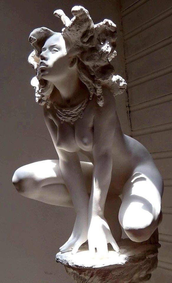 a statue of a woman crouching on her knees