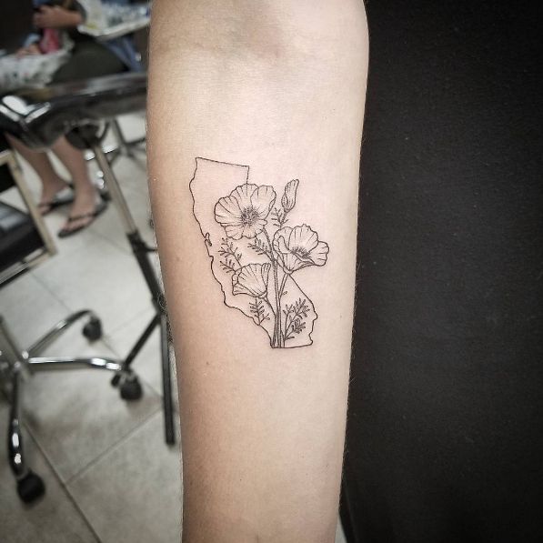 a black and white photo of a flower tattoo on the right arm, with an outline of flowers in it