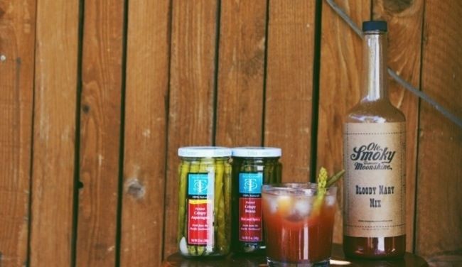 three different types of drinks sitting on a table next to a bottle and some glasses