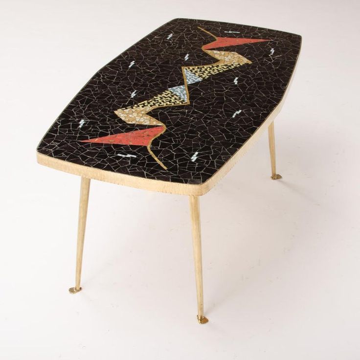 a black and gold mosaic table with two legs on each side, one leg up to the other