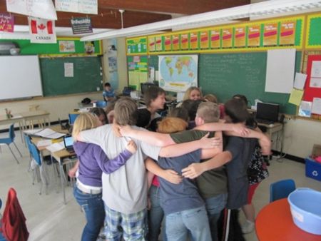 a group of children hugging each other in a classroom