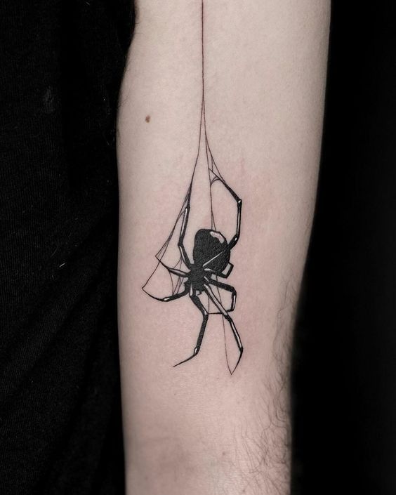 a black and white spider tattoo on the arm