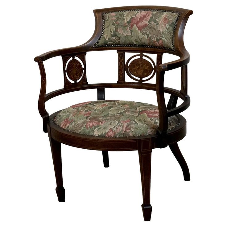 a wooden chair with a floral upholstered back and arm rest on an isolated white background