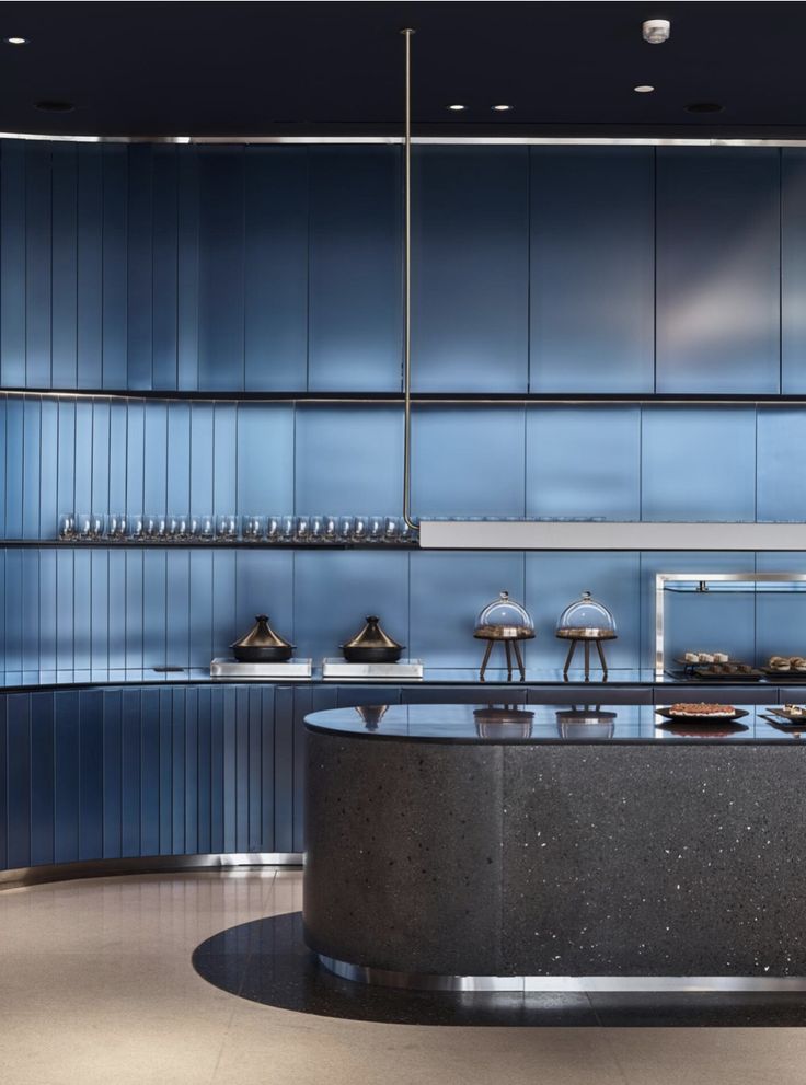 a kitchen with blue cabinets and counter tops in an office building or conference room that is well lit