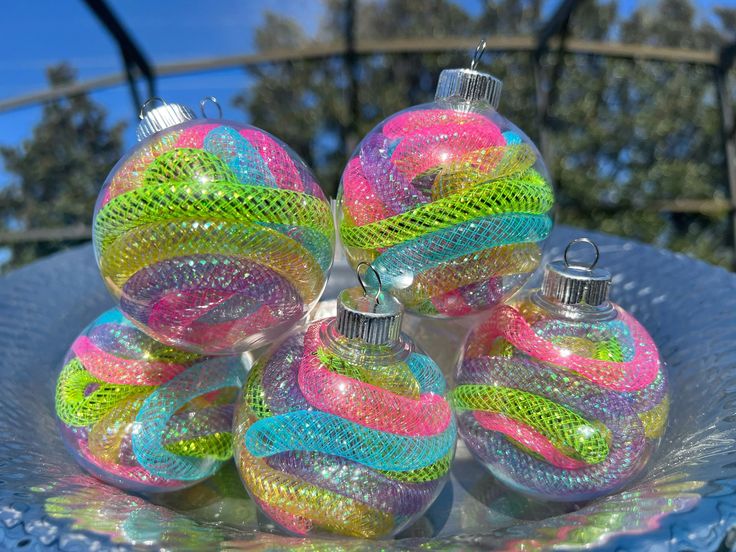 four glass ornaments sitting on top of a blue plate