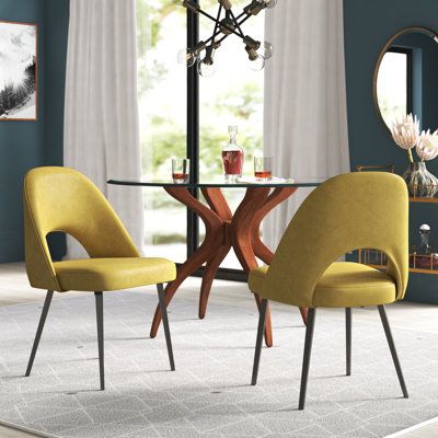 a glass table with yellow chairs around it