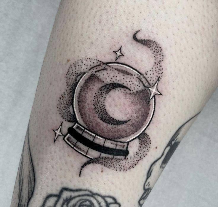 a close up of a person's leg with a tattoo on it and an object in the background