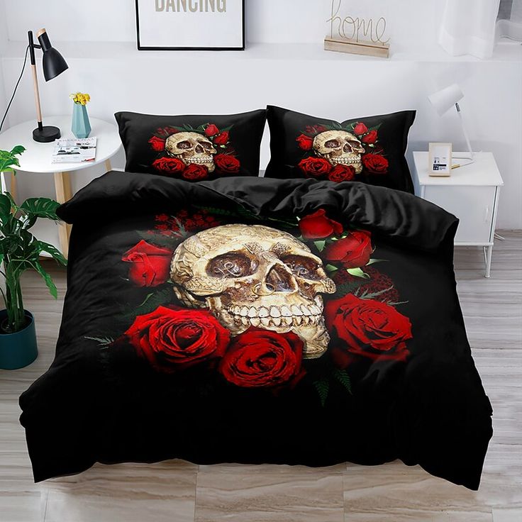 a skull and red roses on a black bed cover with matching pillow cases in a room