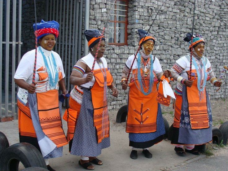 four women dressed in orange and blue clothing