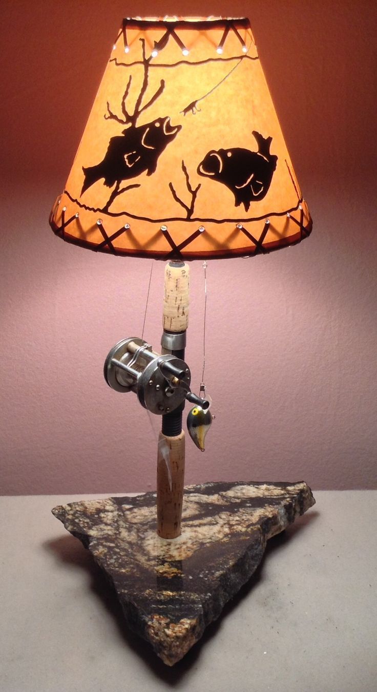 a lamp that is sitting on top of a wooden block with a fishing rod attached to it