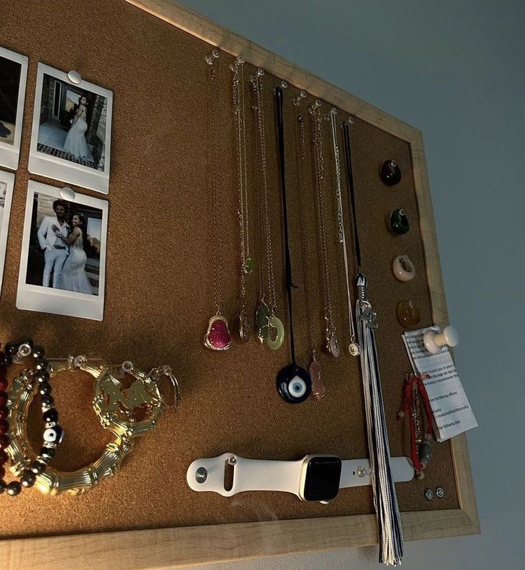 a cork board with pictures and jewelry on it next to a pair of knifes