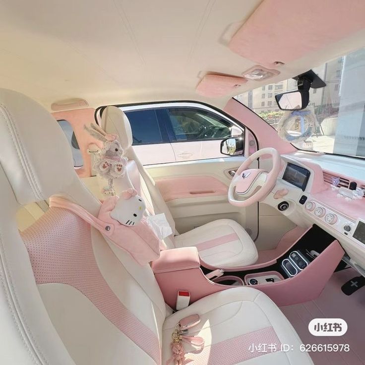 the interior of a pink and white car with stuffed animals on the steering wheel seat