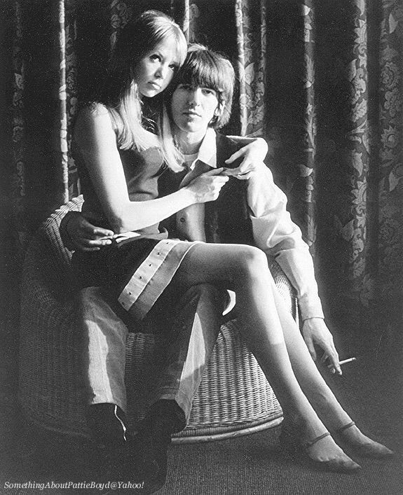 black and white photograph of two people sitting on a chair looking at a cell phone